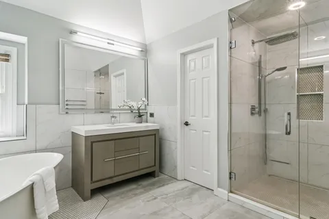 a bathroom with a double vanity sink mirror and shower