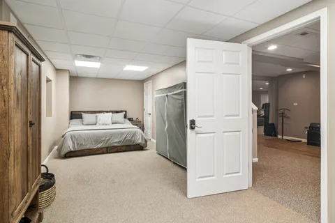 a bedroom with a bed and a refrigerator