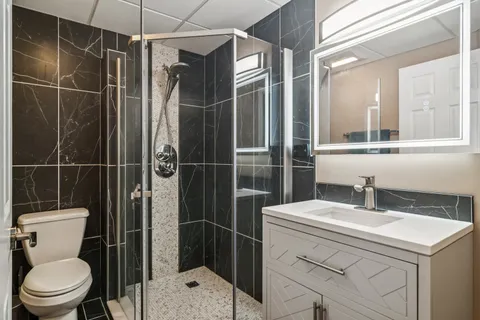 a bathroom with a sink toilet and shower