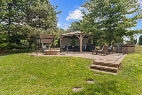a front view of a house with garden and sitting area