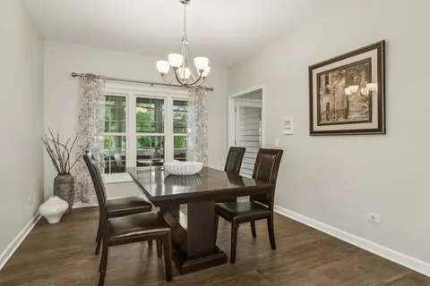 a view of a dining room with furniture a chandelier and wooden floor