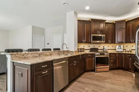 a kitchen with a sink stove top oven and microwave