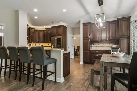 a kitchen with refrigerator cabinets dining table and chairs