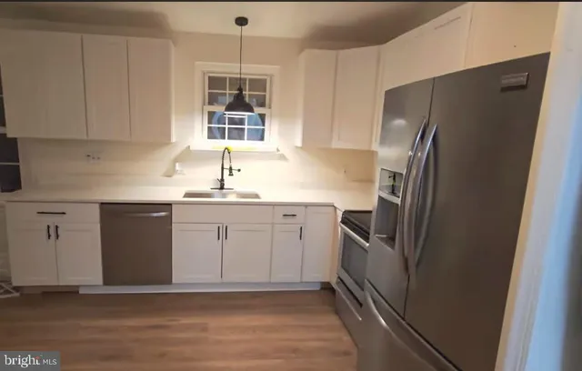 a kitchen with stainless steel appliances a refrigerator sink and cabinets