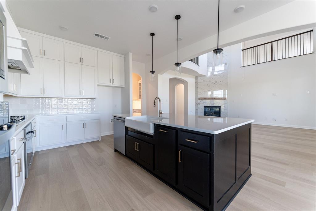 3912 Friendship Court Forney, TX 75126 - Photo 11 of 28 a kitchen with stainless steel appliances granite countertop a sink a stove a refrigerator and island with wooden floor