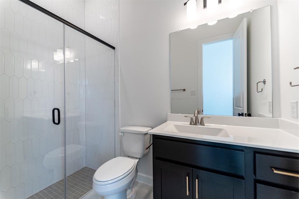 3912 Friendship Court Forney, TX 75126 - Photo 25 of 28 a bathroom with a sink a toilet a mirror and shower