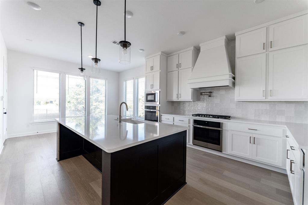 3912 Friendship Court Forney, TX 75126 - Photo 8 of 28 a large kitchen with stainless steel appliances granite countertop a sink a stove and a wooden floors