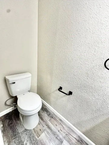 a white toilet sitting next to a white wall