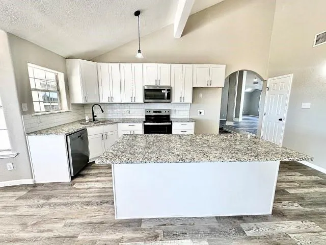 a kitchen with stainless steel appliances granite countertop a sink stove and refrigerator