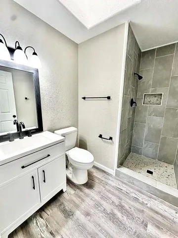 a bathroom with a double vanity sink toilet and shower