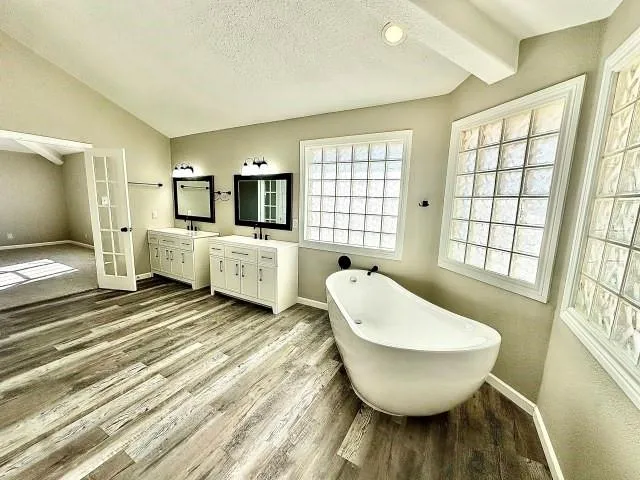 a spacious bathroom with a double vanity sink and a bathtub