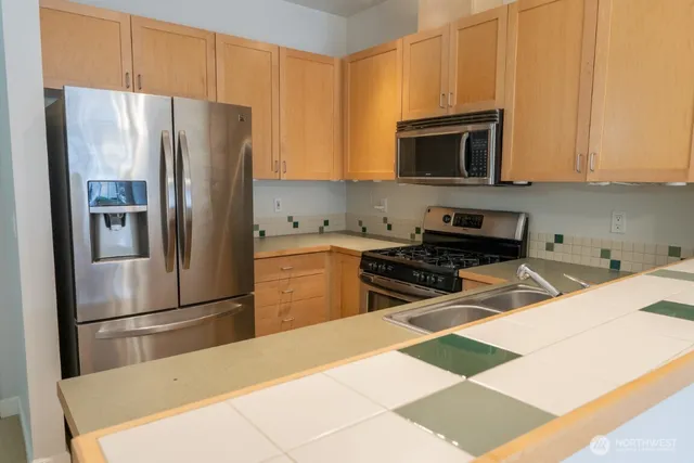 a kitchen with stainless steel appliances granite countertop a refrigerator and a stove