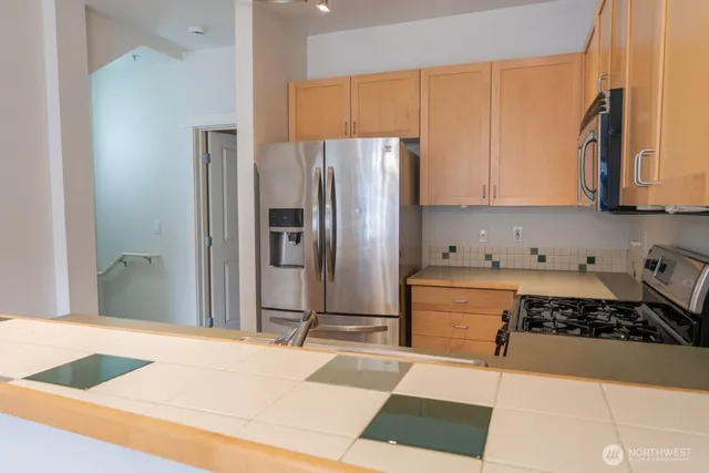 a kitchen with granite countertop a refrigerator stove and microwave