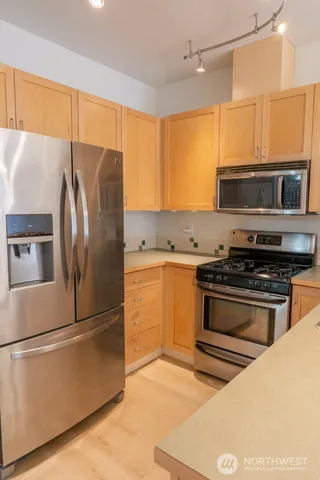 a kitchen with stainless steel appliances granite countertop a stove and a microwave