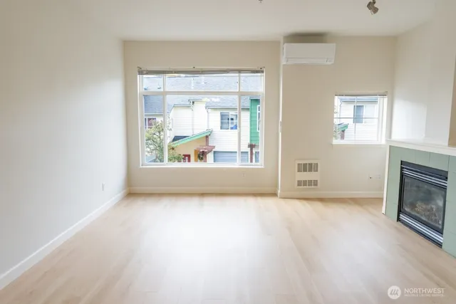 a view of an empty room with a fireplace and a window