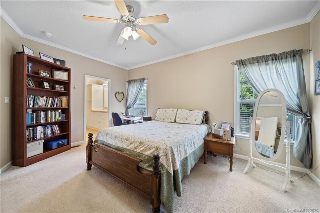 135 Ridge Field Drive Hendersonville, NC 28792 - Photo 12 of 28 a spacious bedroom with a bed a dresser and book shelf