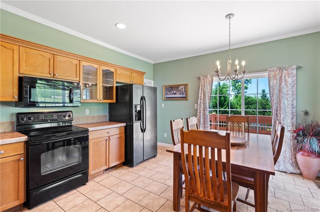135 Ridge Field Drive Hendersonville, NC 28792 - Photo 7 of 28 a kitchen with stainless steel appliances granite countertop a stove a refrigerator a kitchen island a table and chairs
