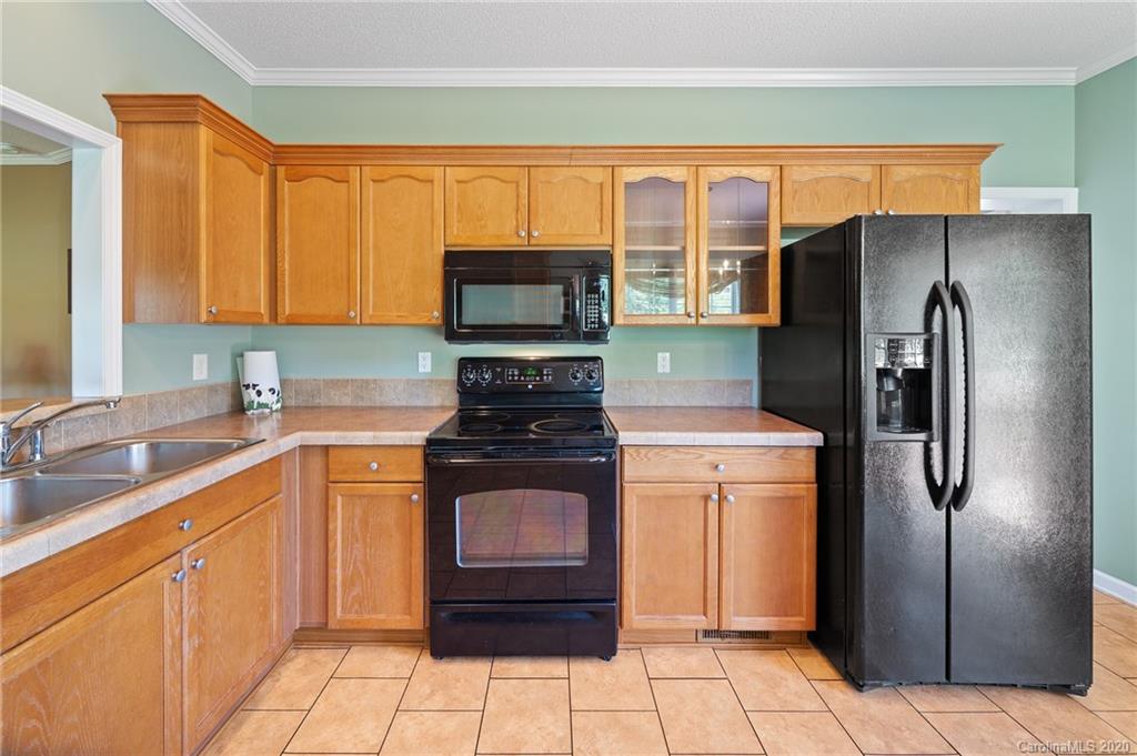 135 Ridge Field Drive Hendersonville, NC 28792 - Photo 8 of 28 a kitchen with stainless steel appliances granite countertop a refrigerator stove and sink