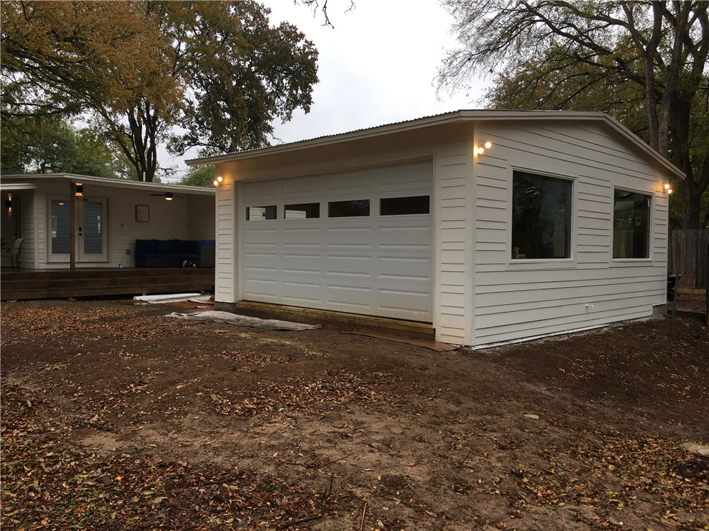 5405 Hudson Street Austin, TX 78721 - Photo 29 of 37 A well-lit detached garage provides ample parking and storage, complementing the adjacent rear deck.