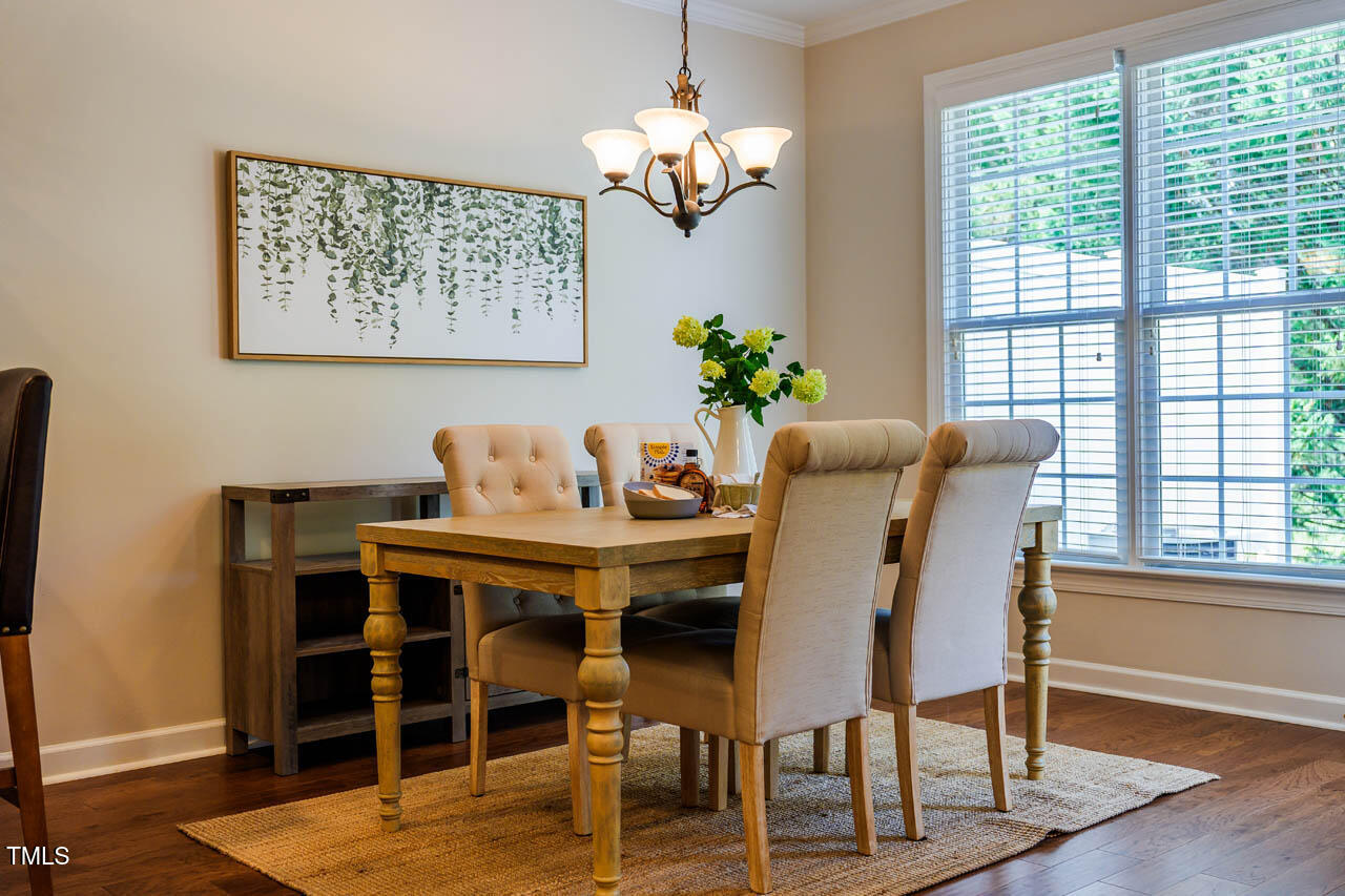 5515 South Roxboro Street, Unit 4 Durham, NC 27713 - Photo 6 of 34 a dining room with furniture a large window and wooden floor