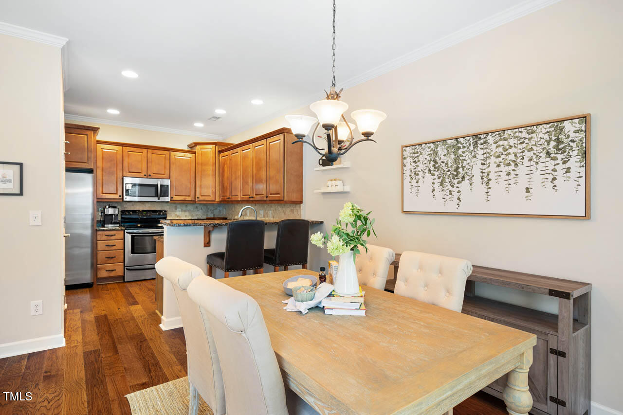 5515 South Roxboro Street, Unit 4 Durham, NC 27713 - Photo 7 of 34 a view of a dining room with furniture a kitchen and chandelier