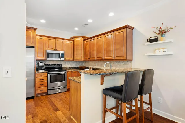 a kitchen with stainless steel appliances granite countertop a stove a sink a microwave and a refrigerator