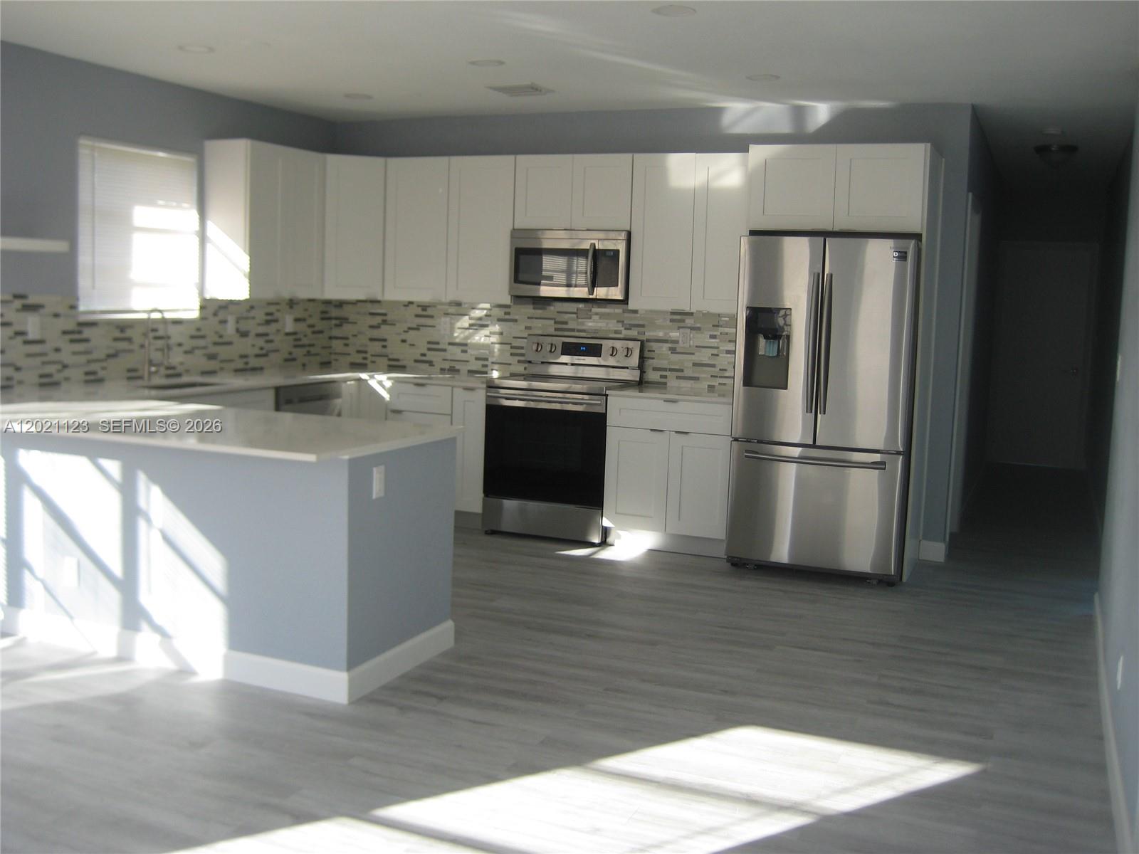 13220 Southwest 99th Place Miami, FL 33176 - Photo 3 of 16 a kitchen with a refrigerator stove and wooden cabinets