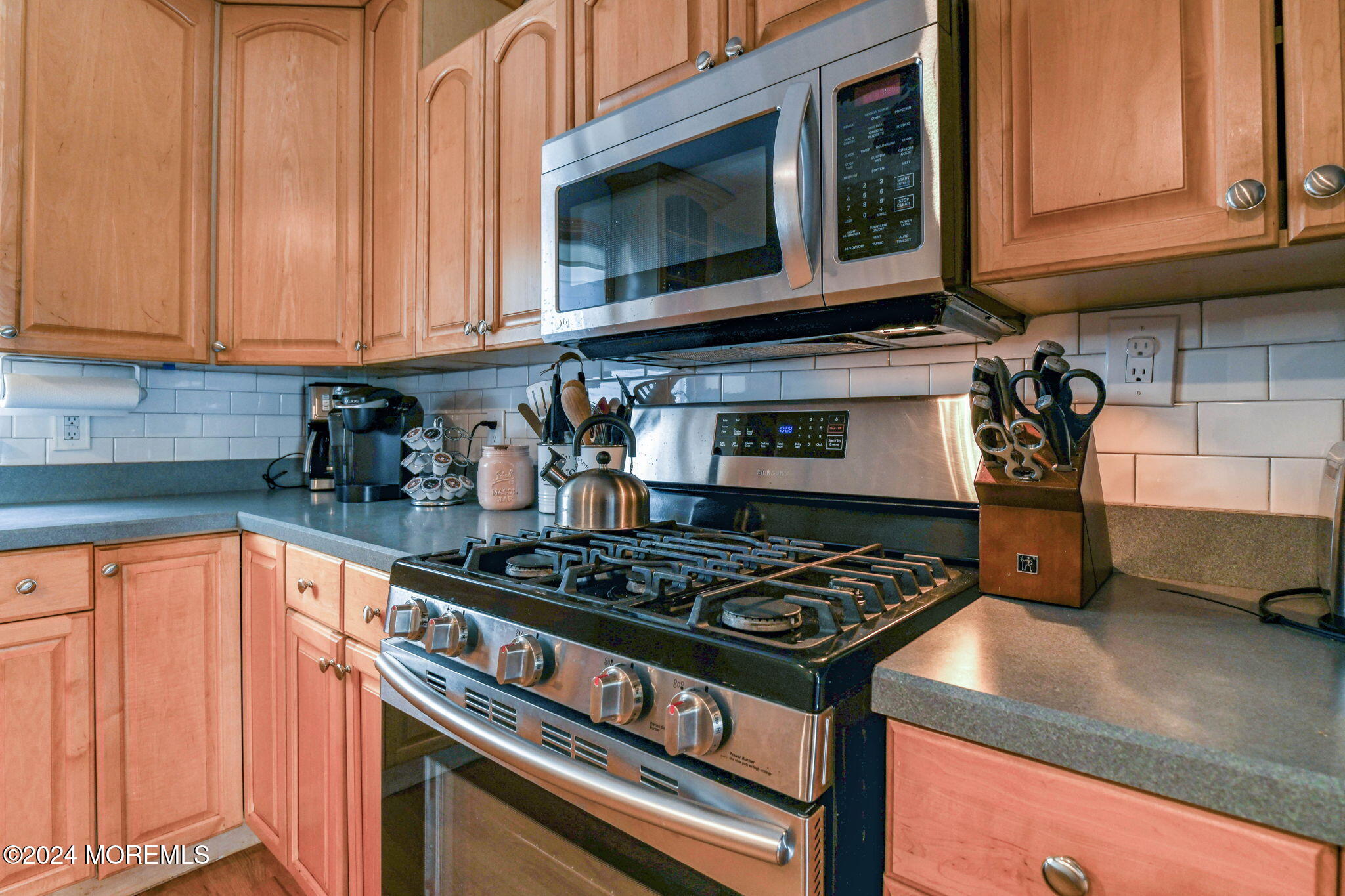 6 1/2 Embury Avenue Ocean Grove, NJ 07756 - Photo 12 of 24 a kitchen with stainless steel appliances granite countertop a stove and a microwave