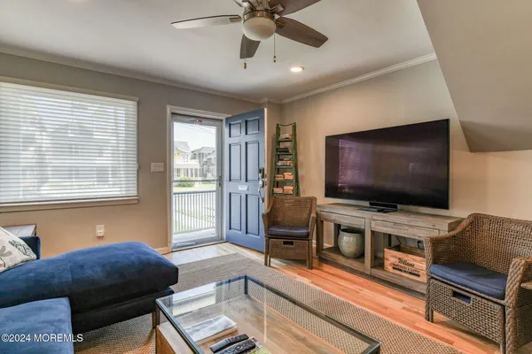 a kitchen with stainless steel appliances granite countertop a refrigerator a sink dishwasher a stove and white countertops with wooden floor