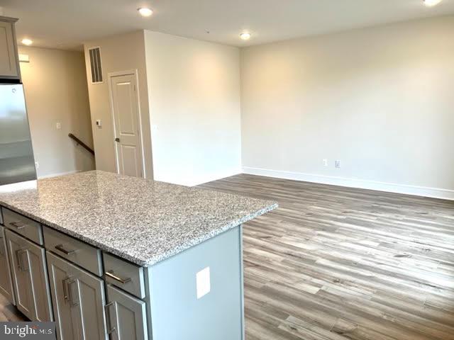43264 Farringdon Square Ashburn, VA 20148 - Photo 11 of 27 a view of kitchen island a sink wooden floor and a cabinet