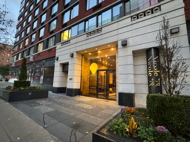 a front view of a building with a garden