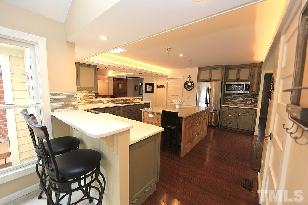 2601 Salisbury Plain Raleigh, NC 27613 - Photo 15 of 30 a kitchen with stainless steel appliances kitchen island granite countertop a stove refrigerator and cabinets