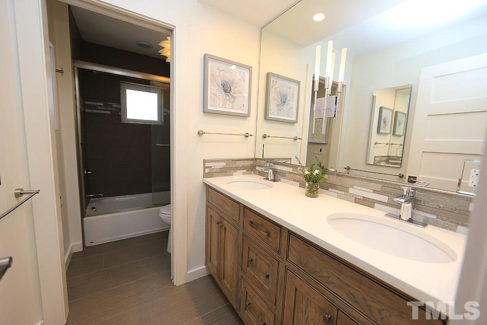 2601 Salisbury Plain Raleigh, NC 27613 - Photo 25 of 30 a bathroom with a double vanity sink a mirror and a bathtub
