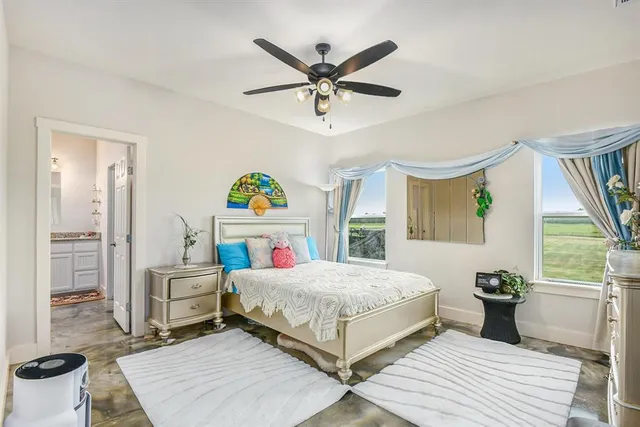 a bedroom with a bed and a large window with wooden floor