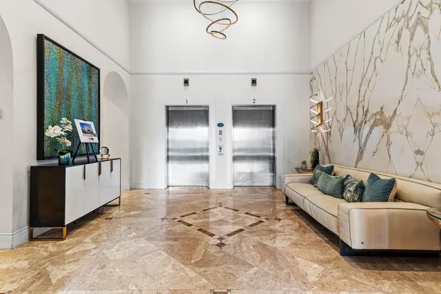 a kitchen with stainless steel appliances granite countertop a stove top oven a refrigerator a dining table and chairs with wooden floor