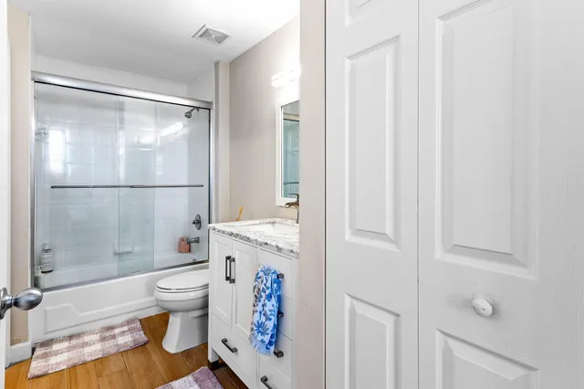 a bathroom with a sink a toilet a mirror and vanity