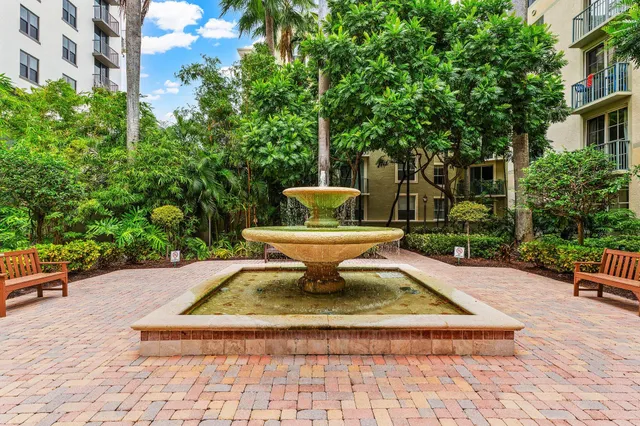 a view of a patio with table and chairs potted plants and large tree