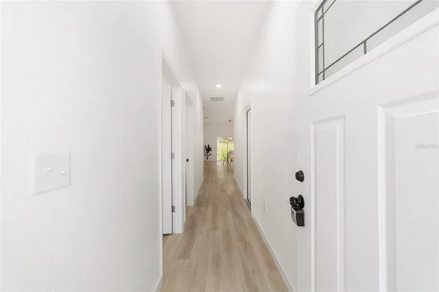a view of a hallway with wooden floor and closet