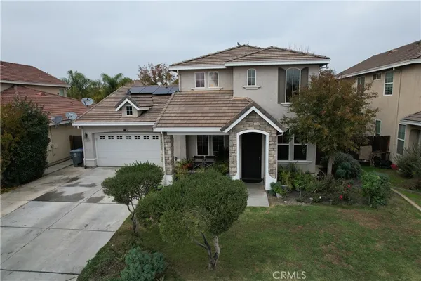 a view of a white house with a yard and plants