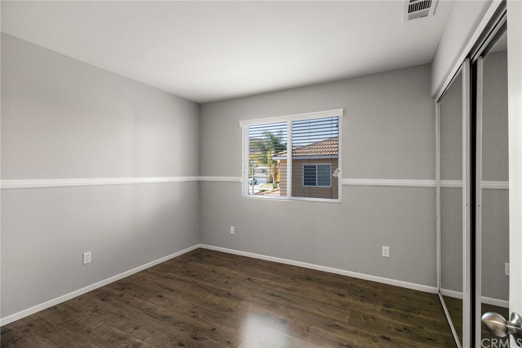 28346 Saddlecrest Street Menifee, CA 92585 - Photo 19 of 35 an empty room with wooden floor and windows