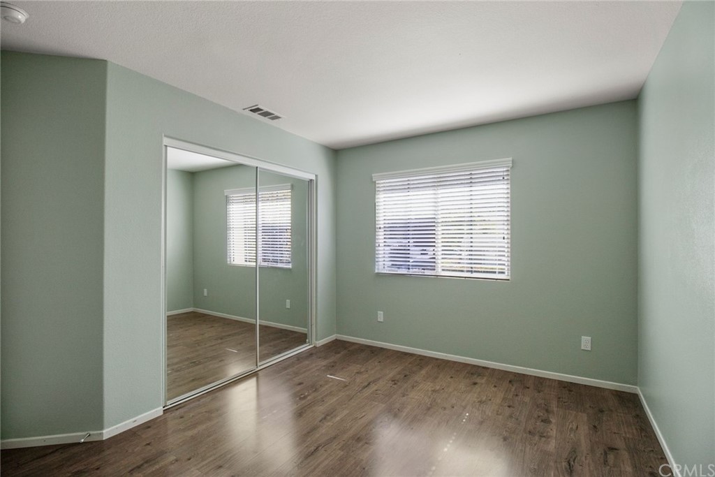 28346 Saddlecrest Street Menifee, CA 92585 - Photo 23 of 35 an empty room with wooden floor and windows