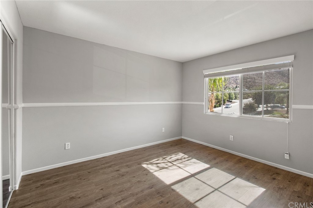 28346 Saddlecrest Street Menifee, CA 92585 - Photo 25 of 35 an empty room with wooden floor and windows