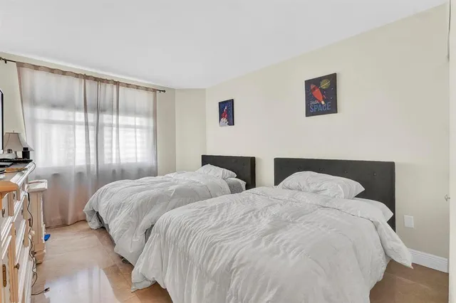 a bedroom with two beds and a window