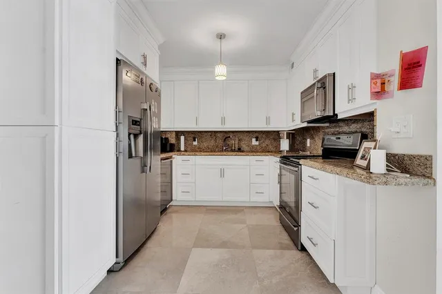 a kitchen with white cabinets and stainless steel appliances