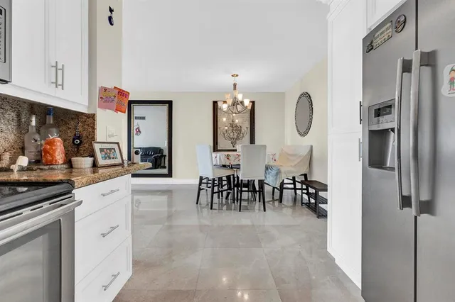 a kitchen with stainless steel appliances granite countertop a refrigerator and a stove top oven