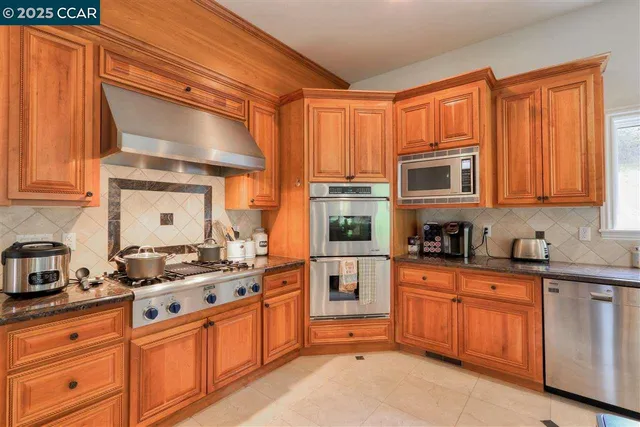 a kitchen with stainless steel appliances granite countertop a stove a sink dishwasher and a microwave oven with cabinets