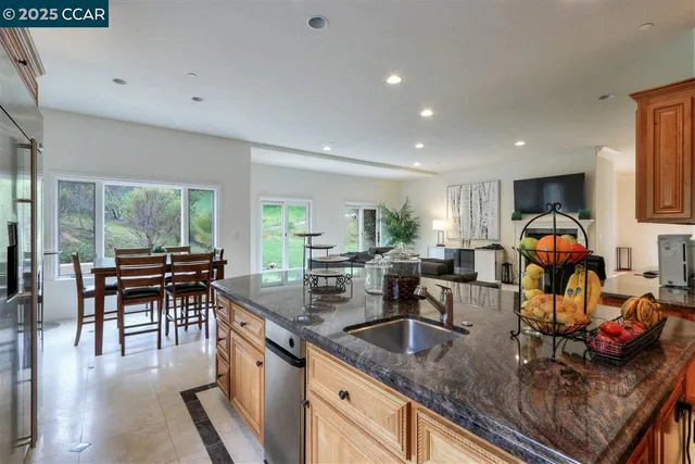 a kitchen with stainless steel appliances granite countertop sink stove and white cabinets with wooden floor