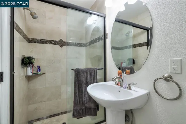 a bathroom with a sink a mirror a vanity and shower