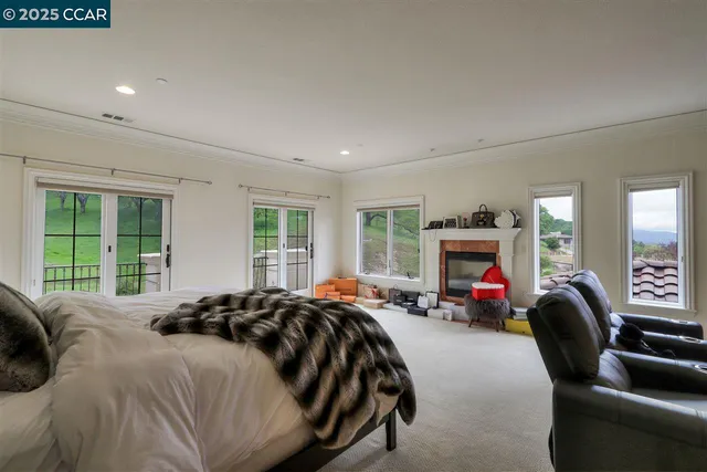 a bedroom with a bed couch and a large window