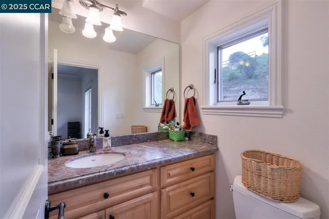 a bathroom with a granite countertop sink and a mirror